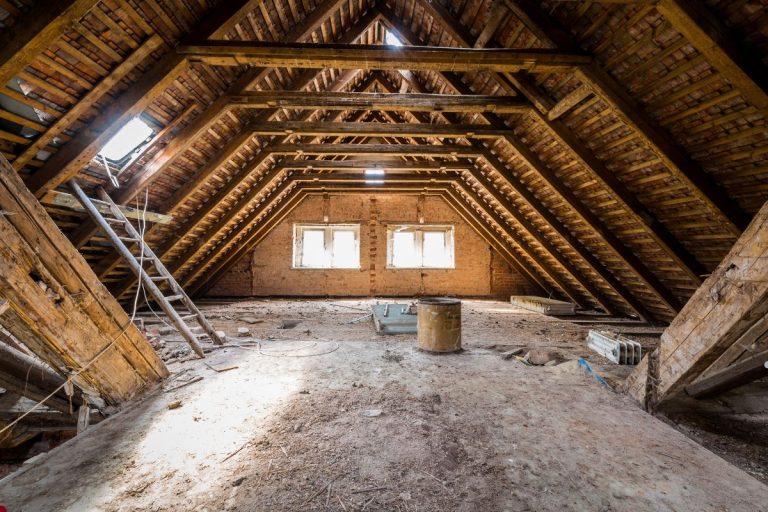 An attic featuring wooden beams and a ladder, showcasing a workspace for furniture repair services.
