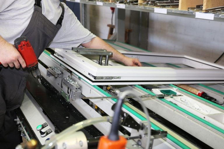 A man focused on operating a large industrial machine in a workshop setting.